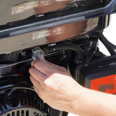 A hand turning off a generator's fuel valve