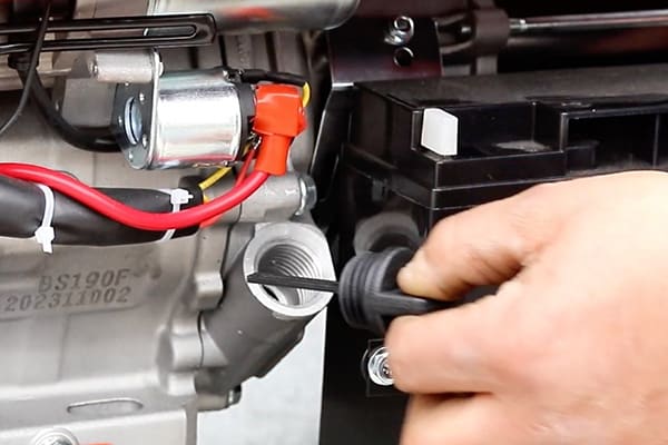 A generator's oil dipstick showing the correct oil level